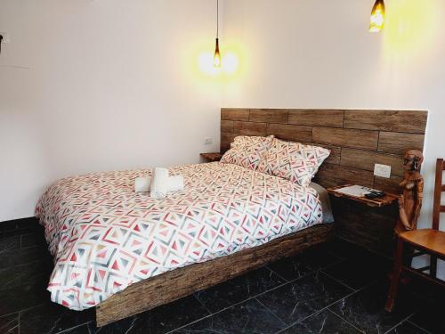a bedroom with a large bed with a wooden headboard at R&B Tree House in Eilat
