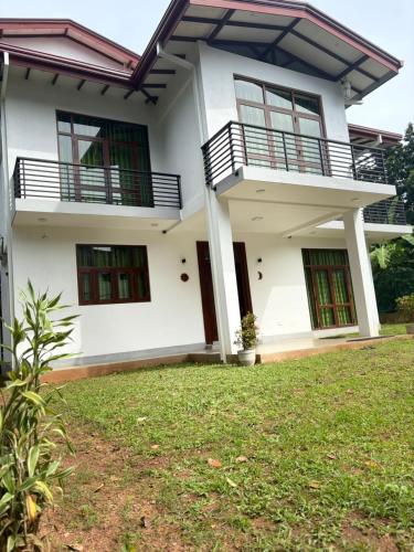 a white house with a lawn in front of it at The Nest Kandana in Kandana