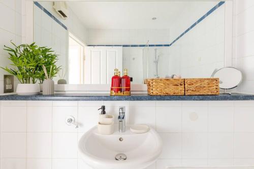 a white bathroom with a sink and a mirror at Modern 1BR Woolwich Flat Elizabeth Line 5 Min in Woolwich