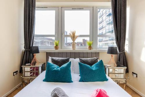 a bedroom with a large bed with blue pillows at Modern 1BR Woolwich Flat Elizabeth Line 5 Min in Woolwich