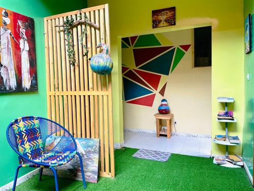 a room with a chair and a colorful wall at Fadidi House in Dakar