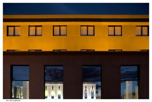 a yellow building with windows at night at ETH Rioja in Haro