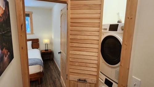 a small room with a bed and a washing machine at Beargrass Lodging & RV Resort in Hungry Horse