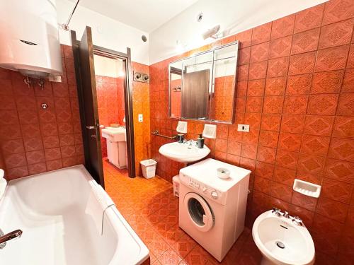 y baño con aseo, lavabo y lavadora. en Incantevole appartamento nelle Dolomiti, en Madonna di Campiglio