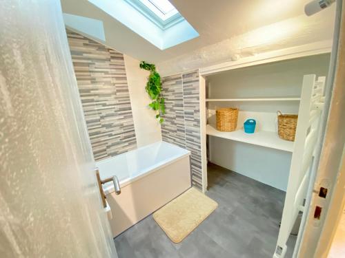 une salle de bain avec une baignoire et une fenêtre dans l'établissement L'Incontournable au cœur de Nîmes, à Nîmes