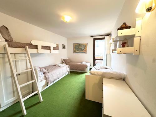 Habitación con 2 literas y suelo verde. en Incantevole appartamento nelle Dolomiti, en Madonna di Campiglio