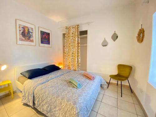une chambre avec un lit et une chaise dans l'établissement L'Incontournable au cœur de Nîmes, à Nîmes