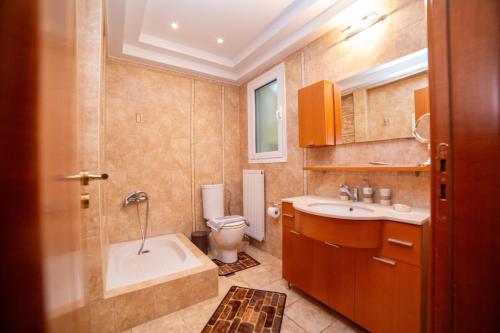 a bathroom with a tub and a toilet and a sink at 2K Eco Villa in Plagiárion