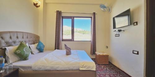 Un dormitorio pequeño con una cama con ventana. en D Kargil View, en Kargil