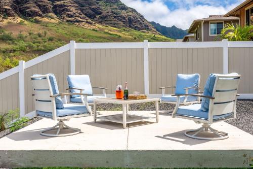 a patio with three chairs and a table and a fence at Mauna View by AvantStay 10min to Beach Backyard in Waianae