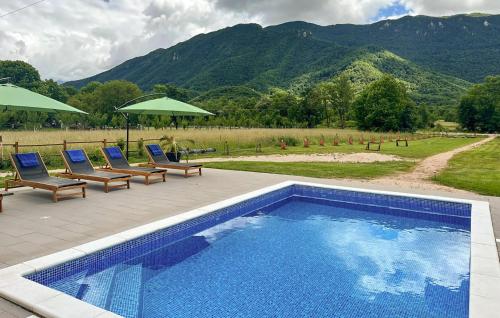 una piscina con sedie e ombrelloni su un patio di 3 Bedroom Nice Home In Brusane a Brušane