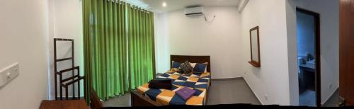 a bedroom with a bed with a green curtain at The Nest Kandana in Kandana