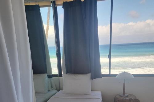 a bedroom with a view of the ocean through the window at The Noniluna Two - Sleeps 9 plus Pack N Play in Lahaina