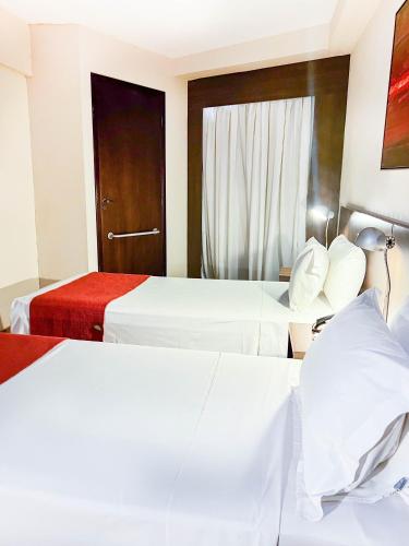 a hotel room with two beds and a window at Royal Design Savassi Hotel in Belo Horizonte