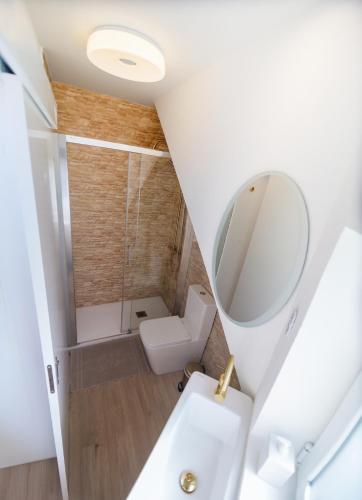 a bathroom with a toilet and a mirror at Wave Shadows Beach House Oceanfront property - Bottom Floor in Paul do Mar