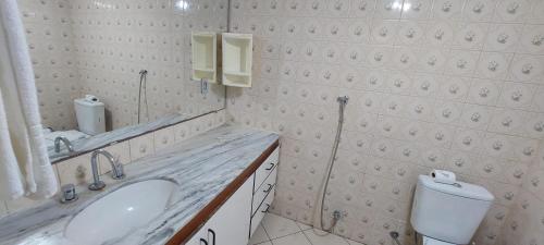 a white bathroom with a sink and a toilet at Dellos Apart Hotel e Administração LTDA in Brasília