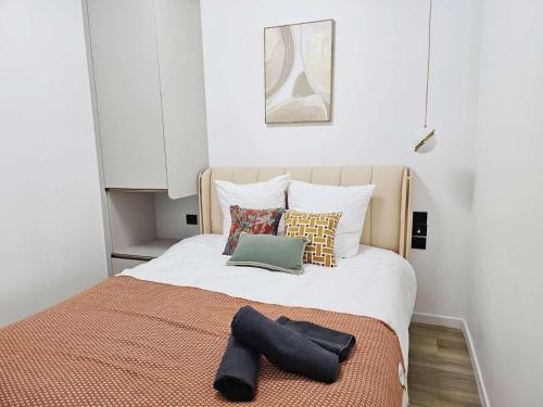 une chambre avec un grand lit blanc avec des oreillers dans l'établissement Charme cosy apt au coeur de paris, à Paris