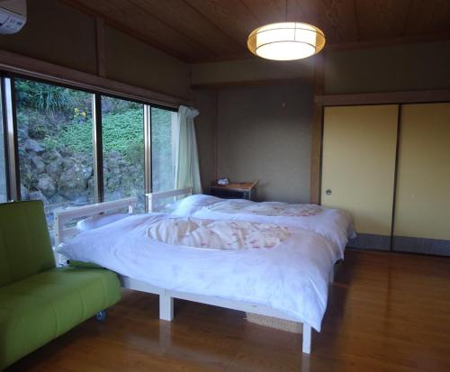 a bedroom with a large bed with a white blanket at Tabiposuto Nonohana - Vacation STAY 89263v in Ito