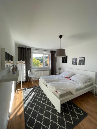 a bedroom with a white bed with a black rug at FeWo Oberwiesenthal in Kurort Oberwiesenthal