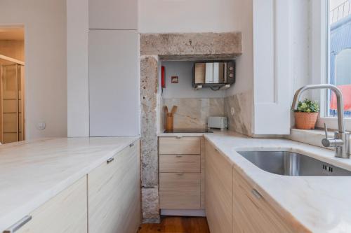 a kitchen with white counters and a sink at Madragoa Studio Zero in Lisbon