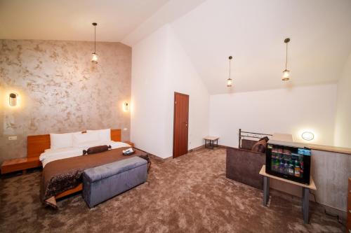 a hotel room with a bed and a flat screen tv at Visota 1880 Hotel Tsaghkadzor in Tsaghkadzor