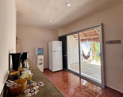 a kitchen with a sliding glass door with a refrigerator at Casa Las Palmas, comfort and privacy in Mahahual