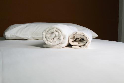a pile of towels and pillows on a bed at Hotel Centro Fashion in Fortaleza