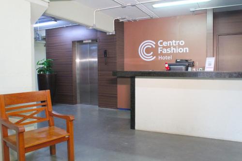 a wooden chair sitting next to a counter in a lobby at Hotel Centro Fashion in Fortaleza