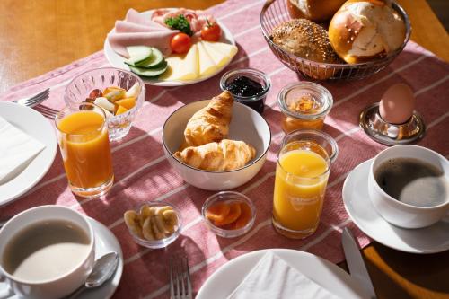 a table topped with breakfast foods and orange juice at Hotel Gasthof zum Ochsen in Ehingen
