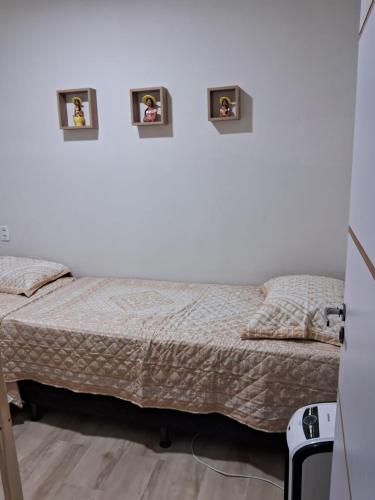 a bedroom with a bed with three pictures on the wall at Casa Recanto Serra Verde in Guaramiranga