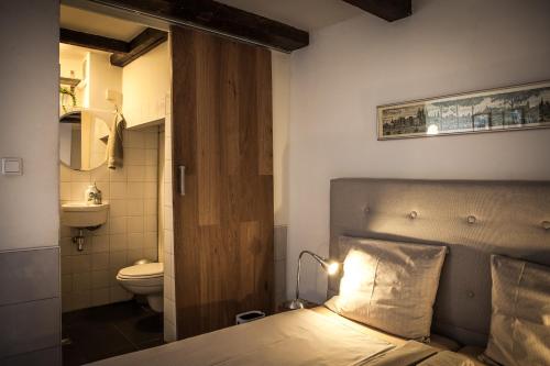 a bedroom with a bed and a bathroom with a toilet at B&B Singel Amsterdam Centre in Amsterdam