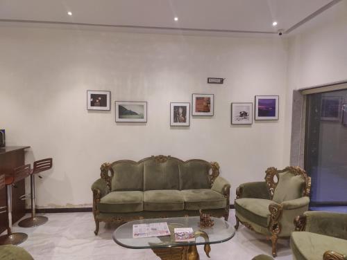 a living room with a couch and two chairs at The V Sadan in Mumbai