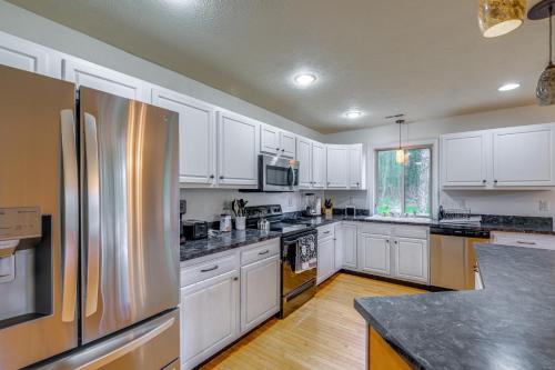 a kitchen with white cabinets and a stainless steel refrigerator at Linden Family Home with Yard Less Than 5 Mi to Wineries! in Front Royal