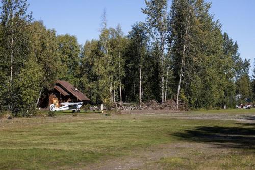 a plane parked in a field next to a house at The Airstrip in Talkeetna