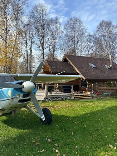 a small plane parked in front of a house at The Airstrip in Talkeetna