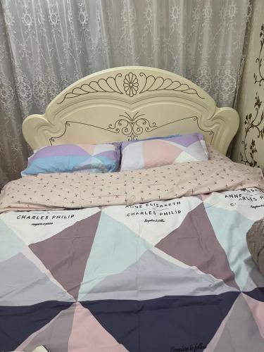 a bed with a quilt and pillows on it at Ethno homestay in Teploklyuchinskoye