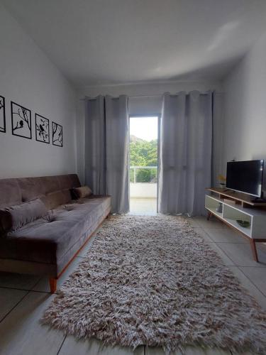 a living room with a couch and a television at Ap sossegado na Praia do Canto in Vitória