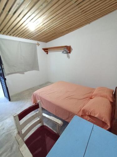 a bedroom with a bed and a table and a chair at Casa de los gatos in San Cristóbal de Las Casas