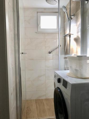 a bathroom with a shower and a washing machine at Apartman Blue Moon Split- free parking in Split