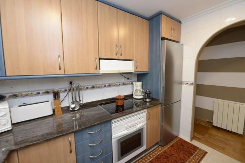 a kitchen with blue cabinets and a white appliance at Ponteareas Precioso apartamento . VUT-PO-011959 in Ponteareas
