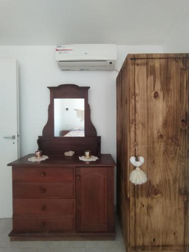 a dresser with a mirror next to a wooden cabinet at Alma de diamante in Cacheuta