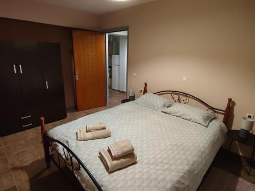 a bedroom with a bed with two towels on it at Thodoris Apartment's in Eptalofos