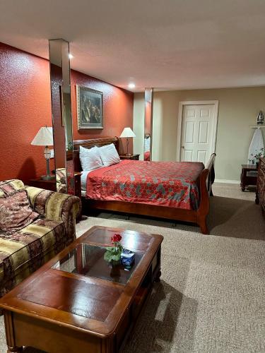 a hotel room with a bed and a coffee table at Western Plaza Inn in De Queen