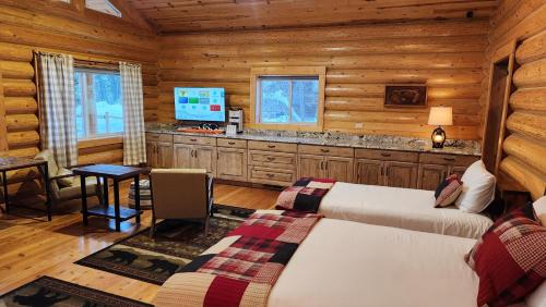 a bedroom with two beds in a log cabin at Beargrass Lodging & RV Resort in Hungry Horse