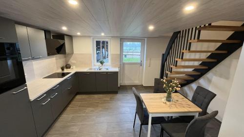 a kitchen and dining room with a table and a staircase at Entspannen zwischen Nord- und Ostsee in Tellingstedt