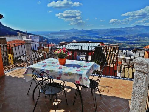 a table on a balcony with a vase of flowers on it at Villa Maddalena con parcheggio privato in Baunei