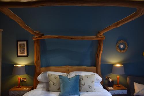 a bedroom with a bed with a blue wall at The Pickled Pheasant in Holmfirth