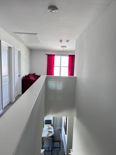 a staircase in a living room with a red window at The Beautiful 31 in Port Wentworth