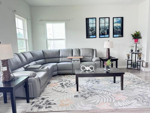 a living room with a gray leather couch at The Beautiful 31 in Port Wentworth