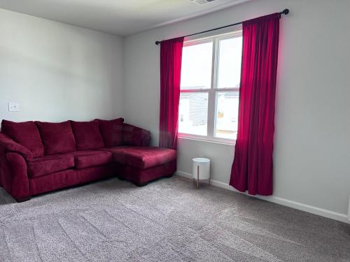 a living room with a red couch and a window at The Beautiful 31 in Port Wentworth